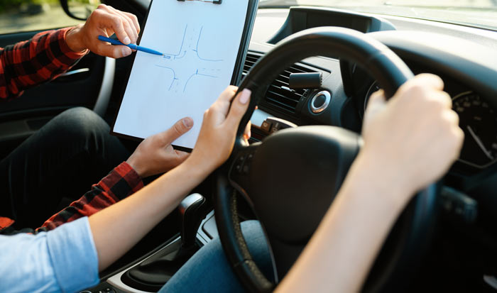 A pupil being shown junctions by her driving instructor