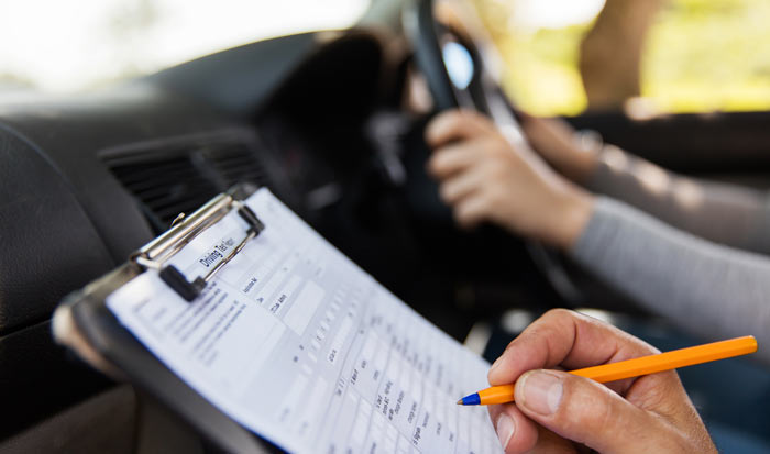 A driving test invigilator marking a test sheet